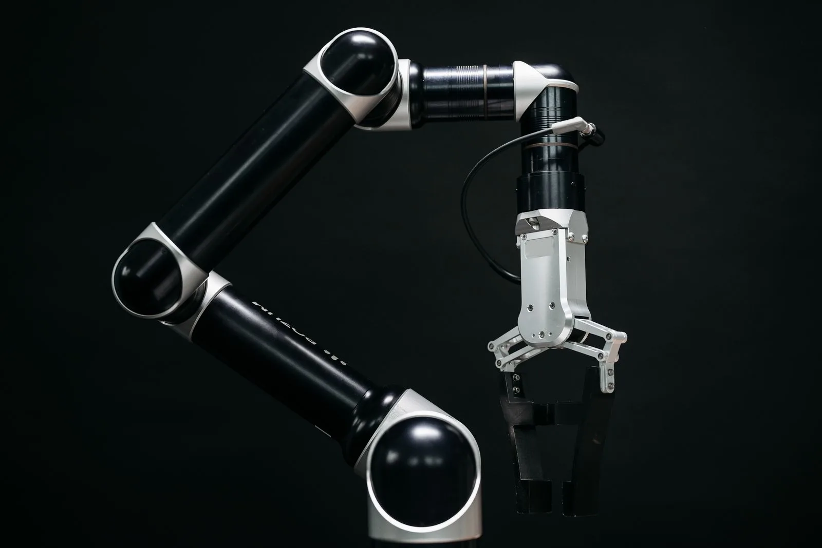 A robotic arm lit in neon against a black background, representing Jev — the decision model that returns answers, not words