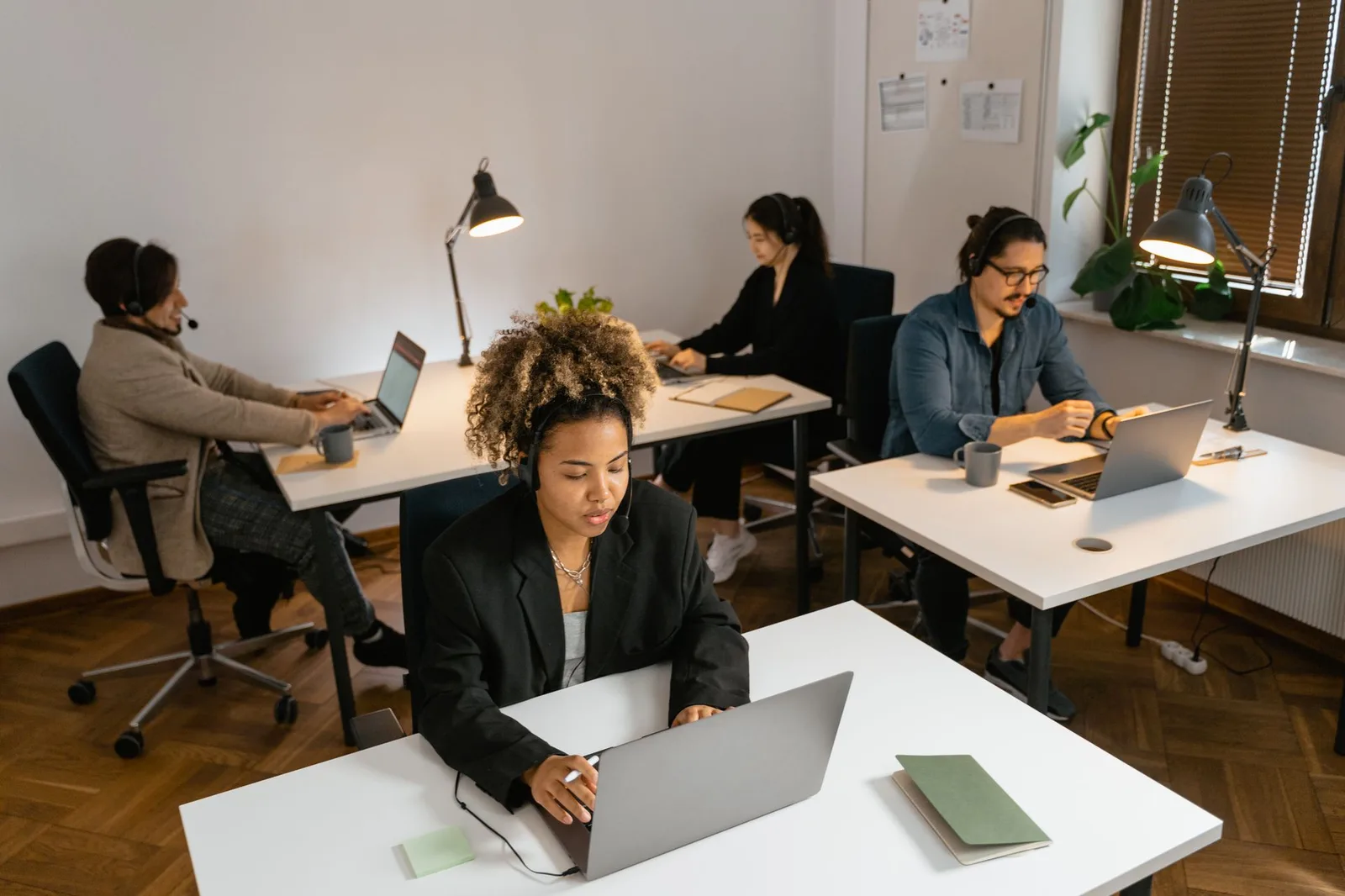 Diverse team of customer-service agents working at computers in a modern office